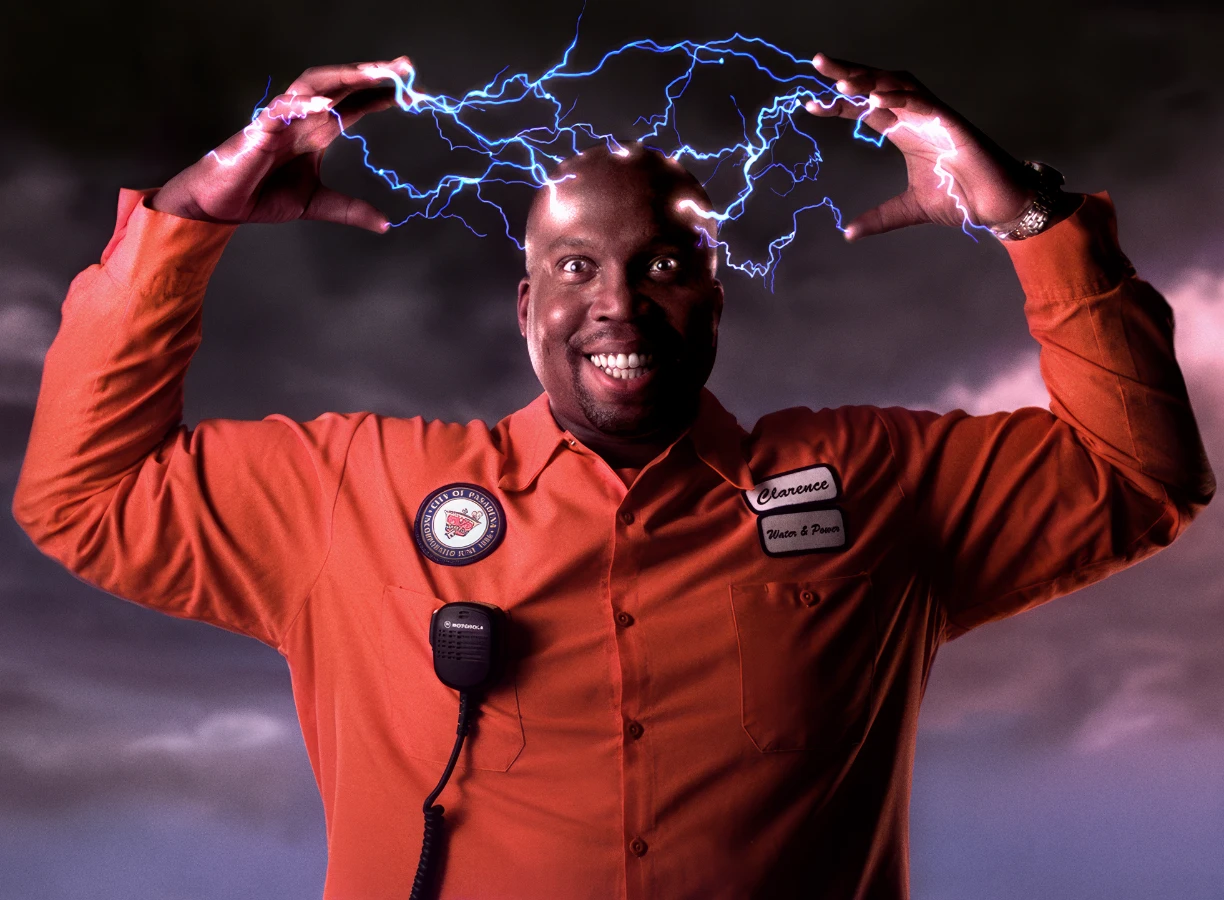 A power company lineman grins while electric sparks jump from his head.